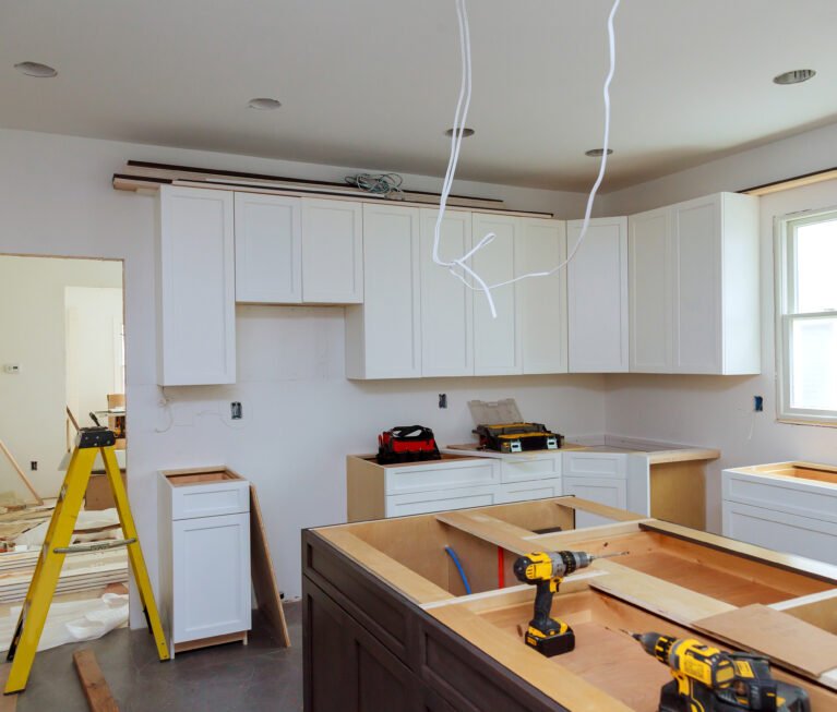 In a set of furniture under construction, white kitchen wooden cabinets were installed with a home improvement view