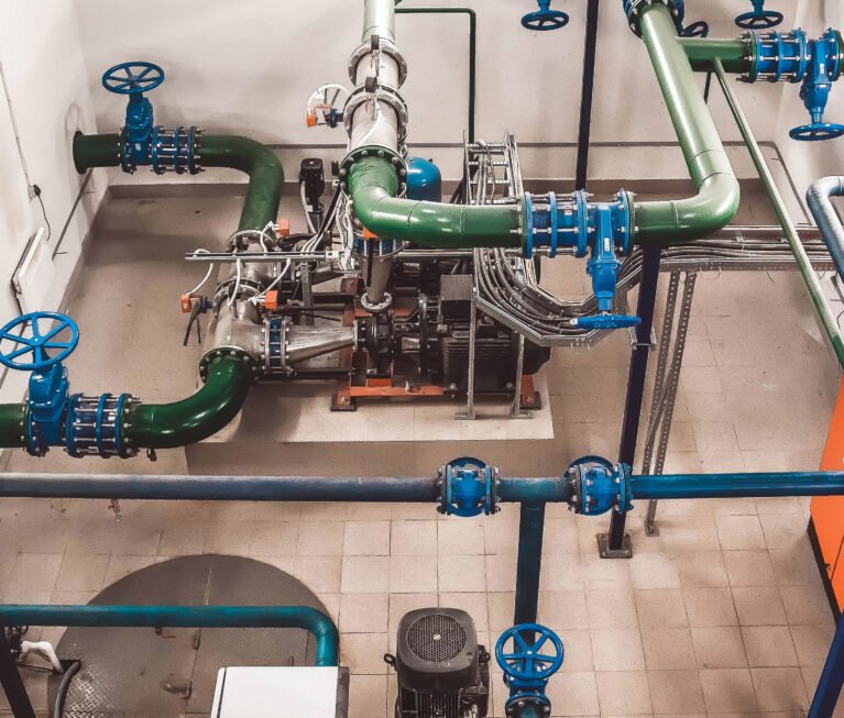 Inside an engine room, the industrial infrastructure showcases a sophisticated water pump system.