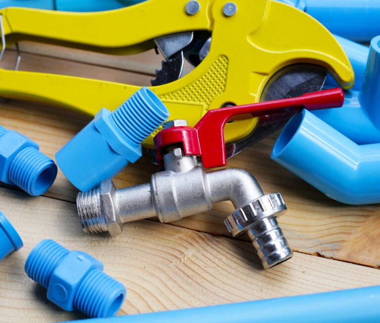 Plumber equipment with blue pvc pipe connections for plumbing work.