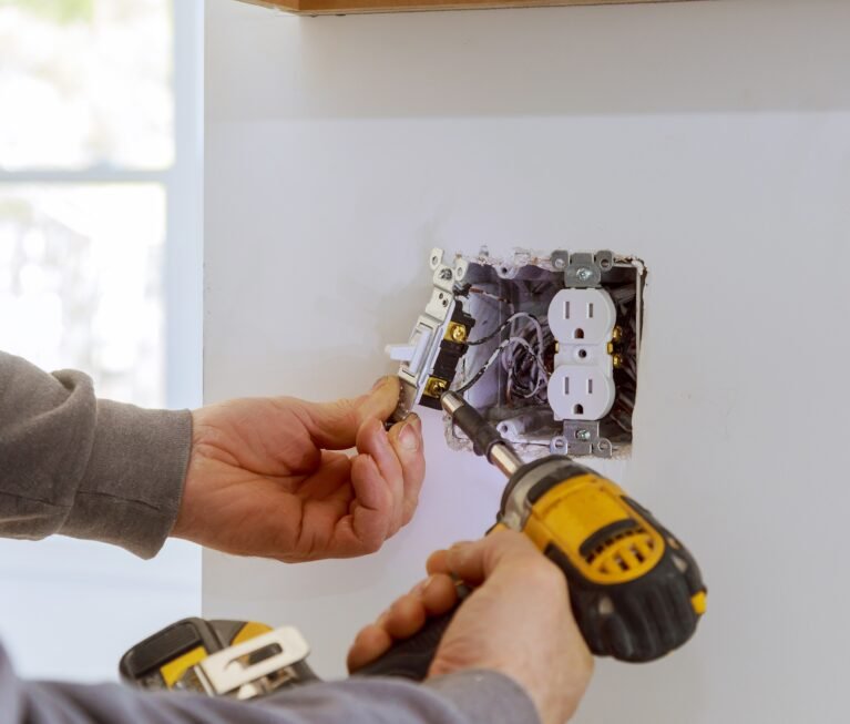 Work on installing electrical outlets with electrical wires and connector installed in plasterboard drywall